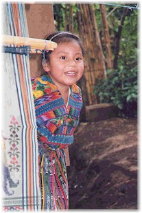 A young Maya girl displays her family's weaving skills.