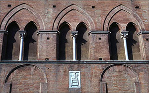 Gothic window and Santa Maria della Scala symbol across from the cathedral. 