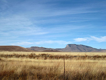 Mountains, grasses, and fence.