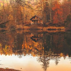 A cabin on a lake during Autumn