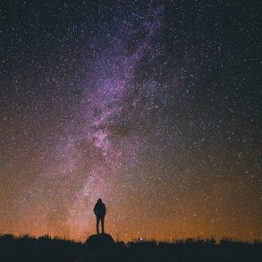 Silhouette of person under starry sky