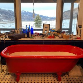 Bathtub with view of high country and mountains through windows