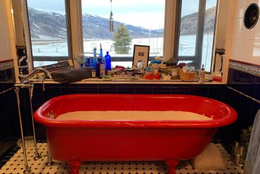 Bathtub with view of high country and mountains through windows