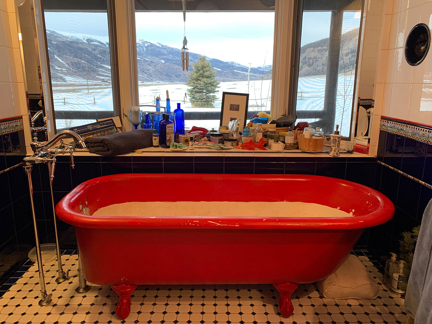Bathtub with view of high country and mountains through windows