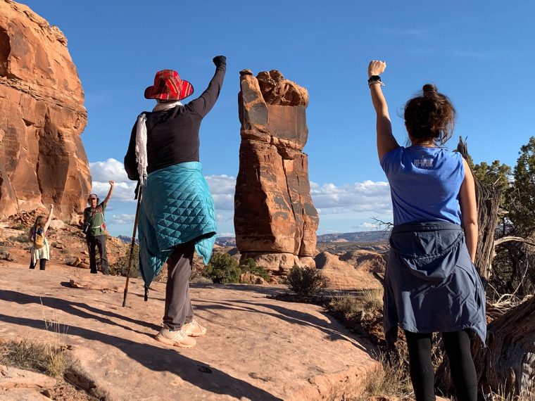 Women in the desert raising fists