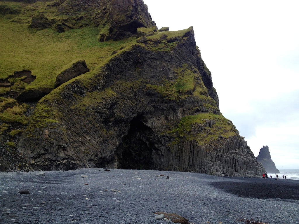 green moss mountain and black sand beach