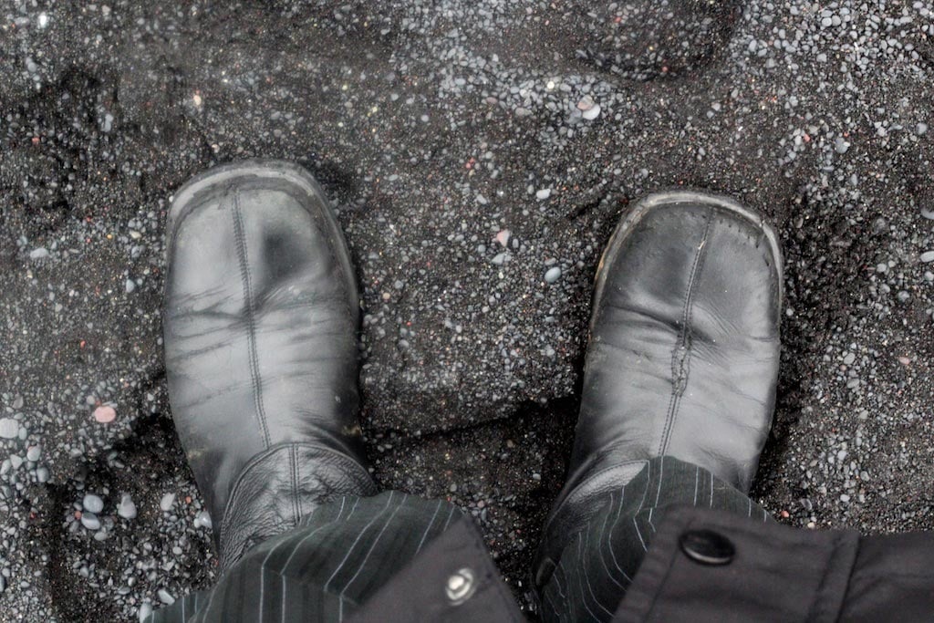 black boots, black sand