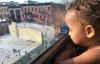 Child looking out window in Brooklyn