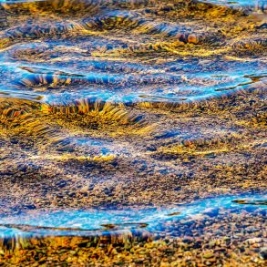 Reflection of light on water above riverbottom