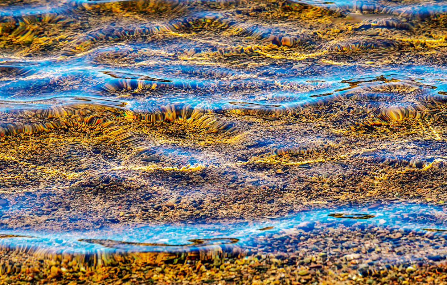 Reflection of light on water above riverbottom