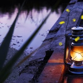 Hurricane lamp at twilight next to river