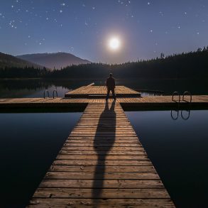 Man on dock with long shadow caused by moon