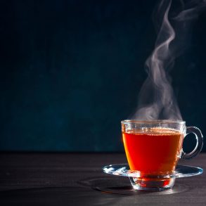 Steaming glass mug of tea