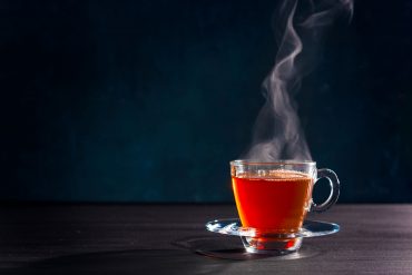 Steaming glass mug of tea