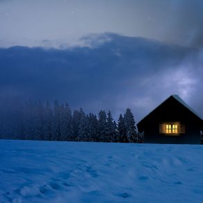 Snowy house with light window
