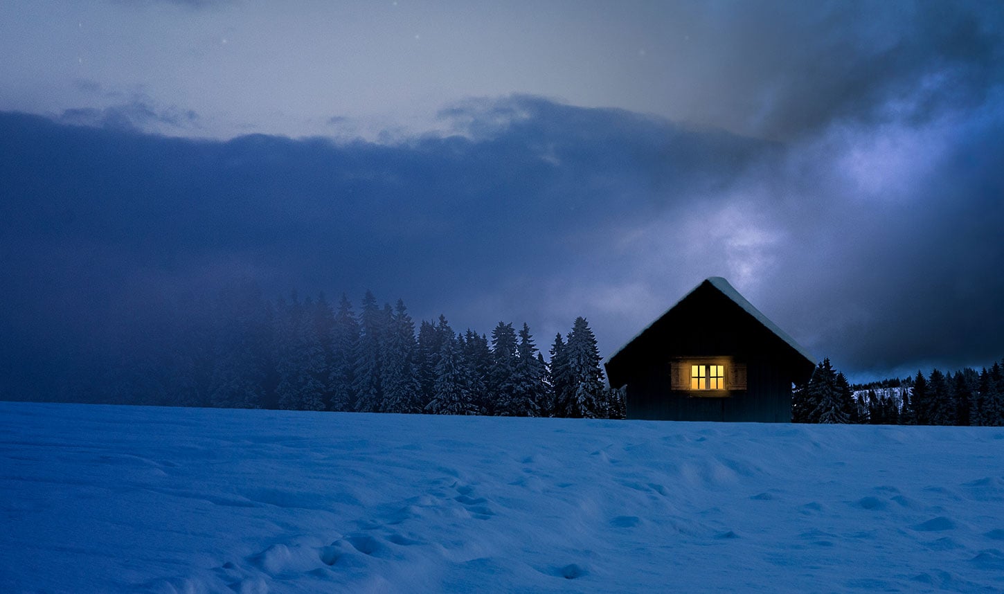 Snowy house with light window