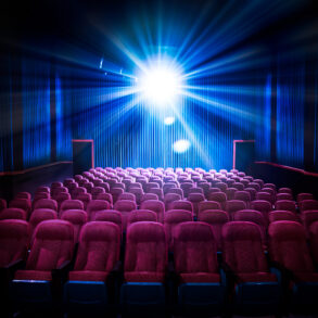 Movie theater with empty seats and projector light