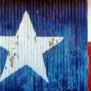 Texas flag painted onto corrugated metal and peeling