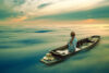 Woman in boat on ethereal sea