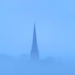 Church steeple in blue fog