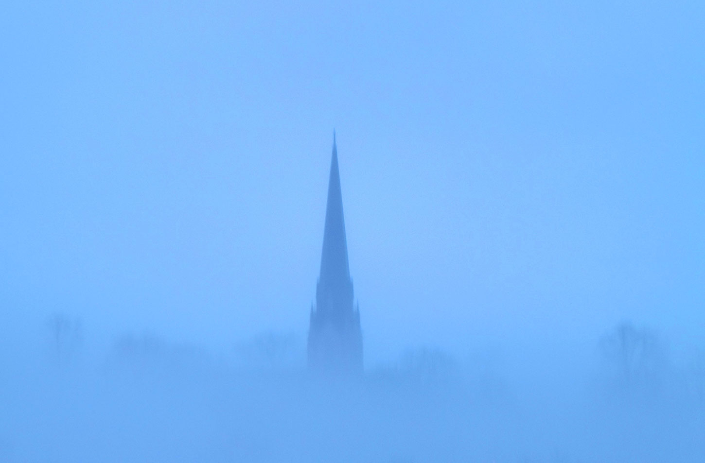 Church steeple in blue fog