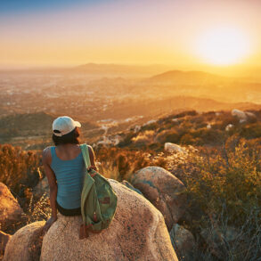 Woman overlooking valley at sunset