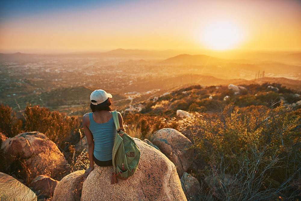 Woman overlooking valley at sunset