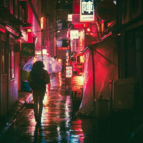 Person with umbrella in rainy alley in Japan with glow or red lights