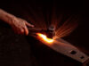 Hand, hammer, anvil, and sparks