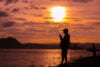 Silhouette of fisherman on lakeshore at sunset