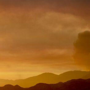 Hills with smoke and orange sky