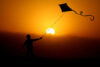Boy with kite at sunset