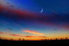 Crescent moon at dusk with rural silhouette