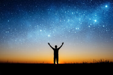 Man silhouetted against starry sky