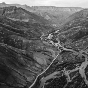 Black-and-white aerial of river and mountains