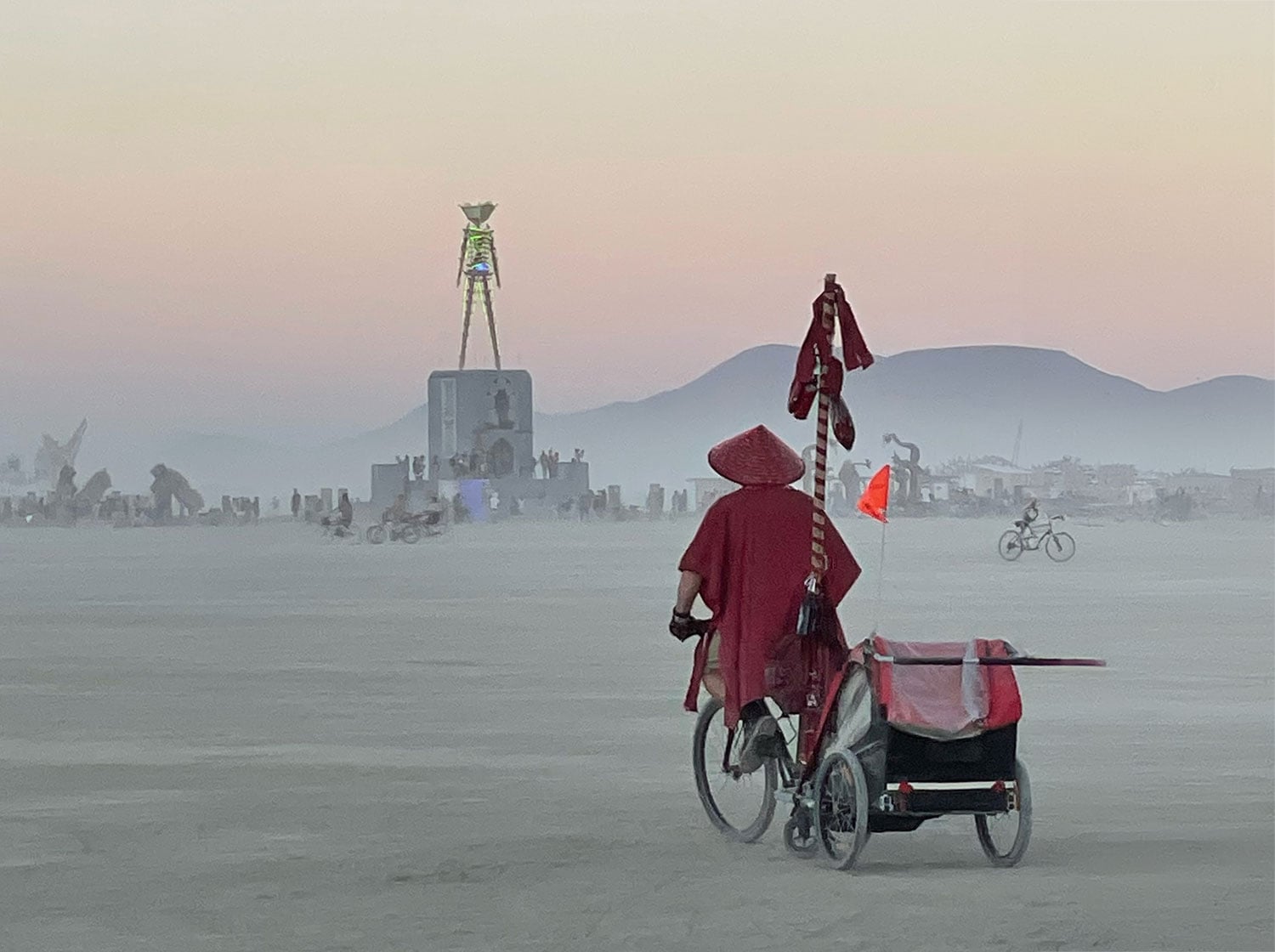 Monk on bicycle at Burning Man at twilight