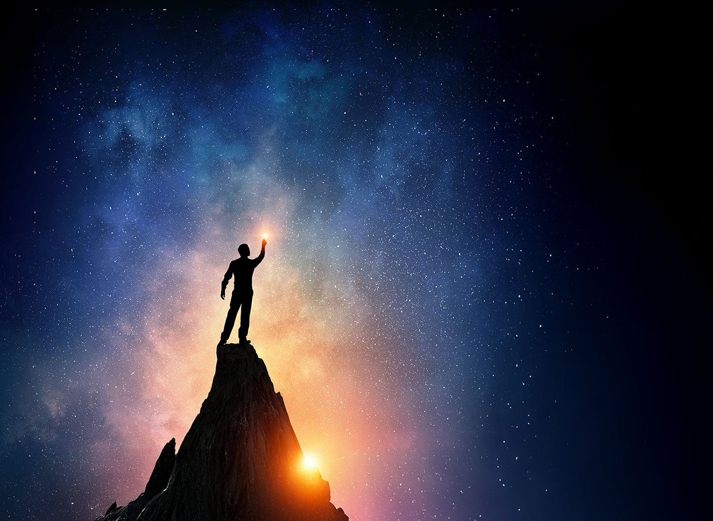 Silhouette of man on peak with stars