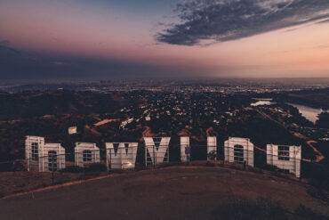 Hollywood sign from behind with view of Los Angeles at twilight