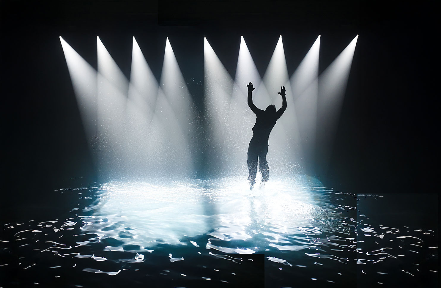 Silhouette of person on stage with water