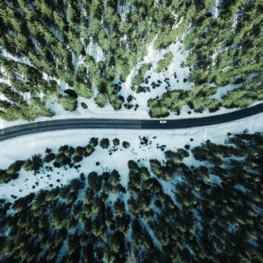 Aerial of road in winter with forest