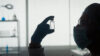 Silhouette of scientist holding vial in lab