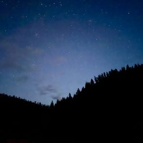 Stars over forested hills silhouette