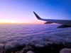 Plane wing above clouds at dusk
