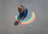 Girl drawing with chalk on sidewalk