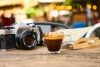 Camera, coffee, and book at ourdoor cafe