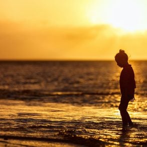 Silhouette of girl at beach at sunset