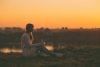 Young woman writing at sunset