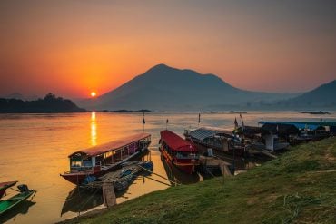 Mekong River sunrise with skiffs and ferry boat