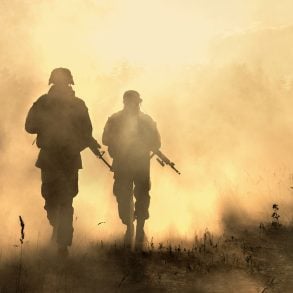 Soldiers walking through smoky field